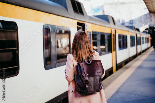 happy young woman walking at train station. Travel concept