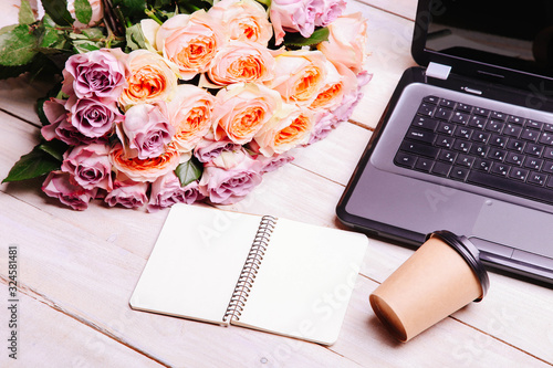 Laptop and bouquet of hybrid tea roses