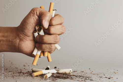 Hand clutching cigarette and crush for destroy.Cigarettes is addictive to be cancer.smoking reduction campaign in World No Tobacco Day.
