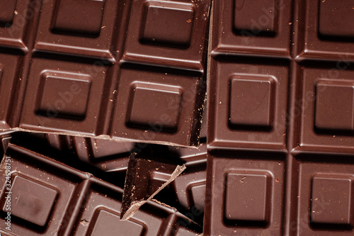 Dark chocolate pieces isolated on white background. Top view.