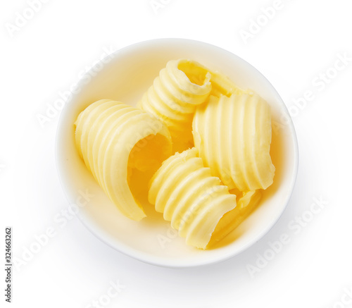 Butter curls or butter rolls in white bowl isolated. Top view.