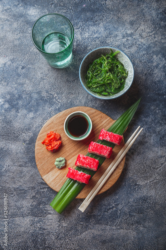 Sashimi sushi set on wooden board. Stone background. Top view