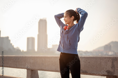 Women tied their hair in preparation for a morning exercise in the city. City running Healthy living in the capital. City view behind. Exercise, fitness, jogging, running, lifestyle, healthy concept.