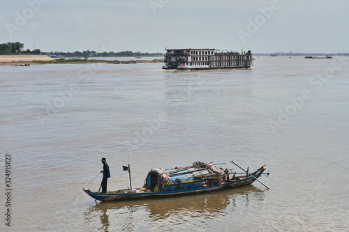 fisherman and boat in the mekong river in phnom penh