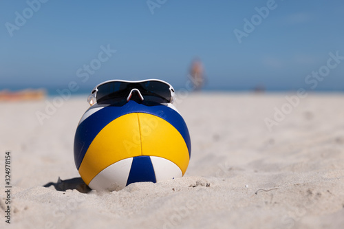 Beach Volleyball. Game ball with glasses on top under sunlight blue sky on sand