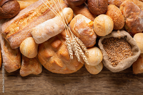 Fresh baked bread and wheat ears, top view