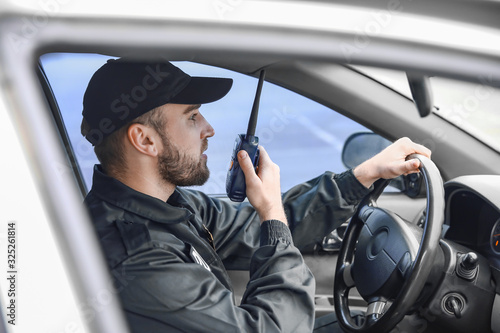 Male police officer driving car