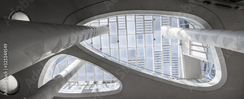 Super wide angle of a white atrium with skylight taken from below with columns that extend upwards