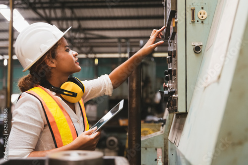 Industrial factory maintenance engineers woman inspect relay protection system of machinery and holding digital tablet with copy space. Industry, Maintenance, Engineering and construction concept.