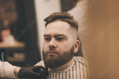 handsome bearded man is a client of a men's salon