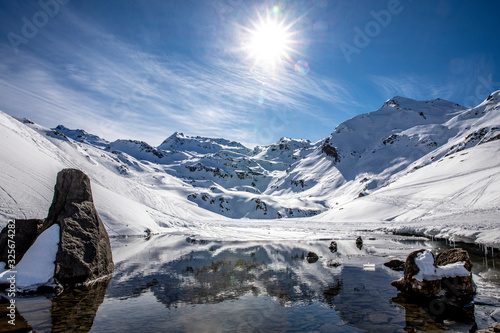 Saint-Martin-de-Belleville, France - February 21, 2020: The snow-covered mountain and its reflection in Lac du Lou near Val Thorens resort