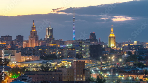 Ostankino tv tower and stalin skyscrapers near railway station day to night timelapse. Residential buildings and roofs at summer in Moscow, Russia