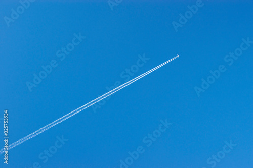 the plane flies in the sky leaving a trail