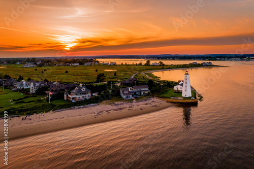 Summer sunset in Old Saybrook along the Connecticut River with Lynde Lighthouse in the foreground and a summer sunset