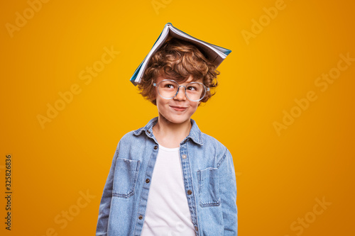 Curious pupil with textbook on head