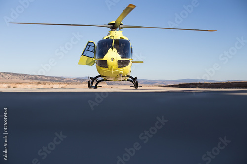 Helicóptero Amarillo sobre cielo azul preparado para iniciar vuelo de ala rotatoria 