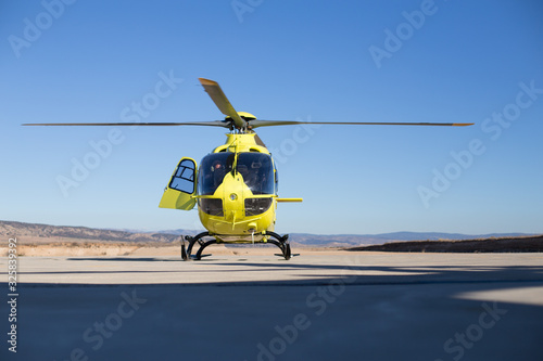 Helicóptero Amarillo sobre cielo azul preparado para iniciar vuelo de ala rotatoria 