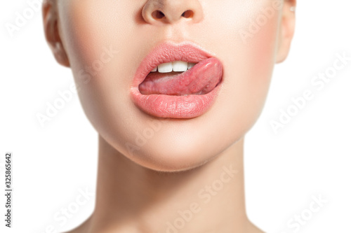 Woman's tongue seductively licking lips. Beautiful chubby lips. seduction concept.