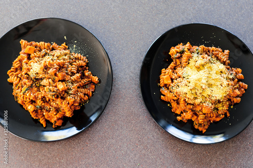 vegan fusilli pasta with lentils pumpkin cubes and kale topped with nutritional yeast