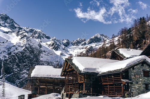 The traditional architecture of the Walser villages in the valleys of Monte Rosa, during a fantastic winter day, near the town of Alagna, Italy - February 2020.