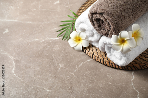Beautiful spa composition with plumeria flowers on grey marble table, above view. Space for text