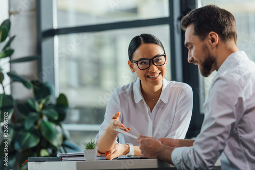 female asian translator working working with smiling businesswoman