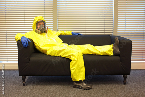 Quarantine - home arrest - professional in protective clothing, lying on the sofa and doing nothing