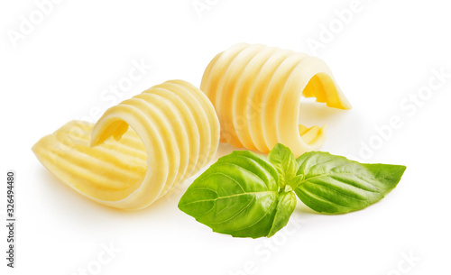 Butter curls or butter rolls with basil leaves isolated on white background
