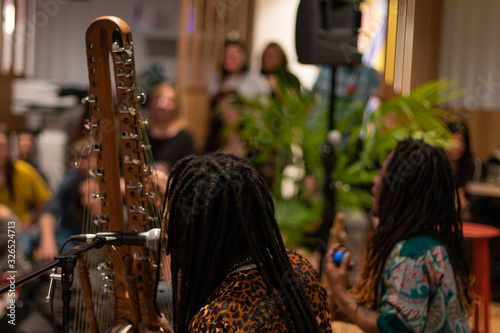 Duet of African musicians from Guinea Conakry play their traditional instruments, the kora and the pumpkin, in a show. Black mans with dreadlocks.