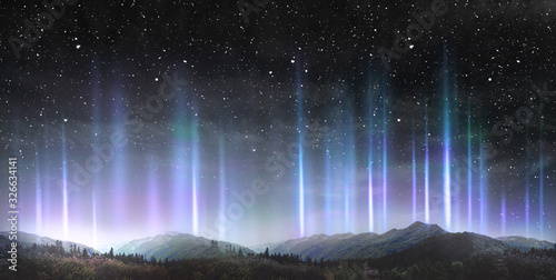 Beautiful colorful light pillars at night over the mountains