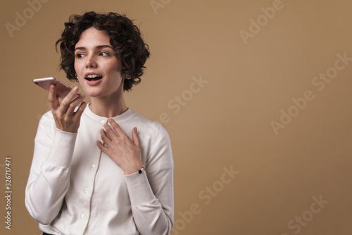 Image of cute beautiful woman standing and talking on cellphone