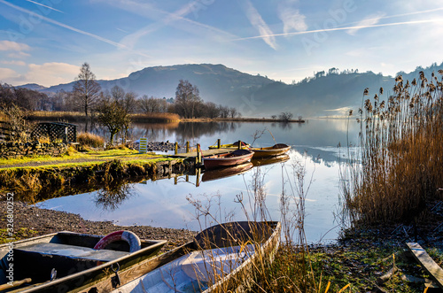 Boats at rest on Grasmere water by the village in the centre of the Lake District Cumbria. . 