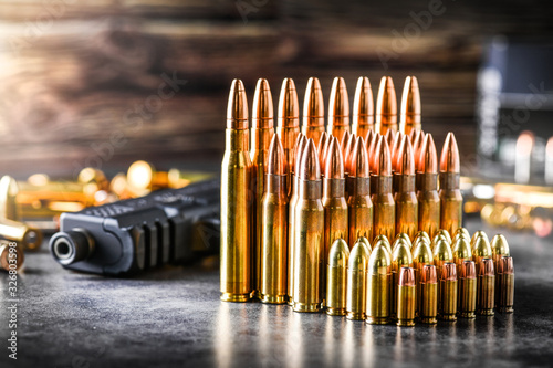 Various kind of bullets or ammonution on dark stone table. Bullet pile in war ammo background. Magazines, rounds and military technology. Banner or panorama guns photo..