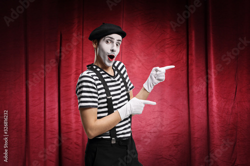 Pantomime man performing in a theater with red curtains