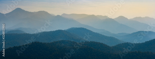 Amazing wild nature view of layer of mountain forest landscape with cloudy sky. Natural green scenery of cloud and mountain slopes background. Maehongson,Thailand. Panorama view.