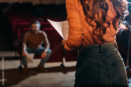 selective focus of theater director and actress with screenplay on stage