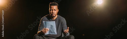 panoramic shot of african american actor holding scenario on stage during rehearse