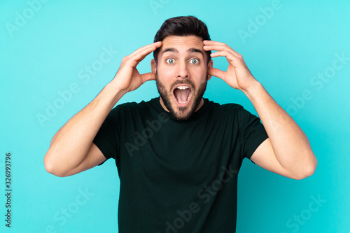 Caucasian handsome man isolated on blue background with surprise expression