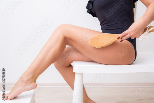 Beautiful Woman Making A Scrub Massage With Big Brush. Dry body brush, Woman dry brushing body to reduce cellulite, detoxify the lymphatic system, and achieve beautifully smooth skin. Dry skin
