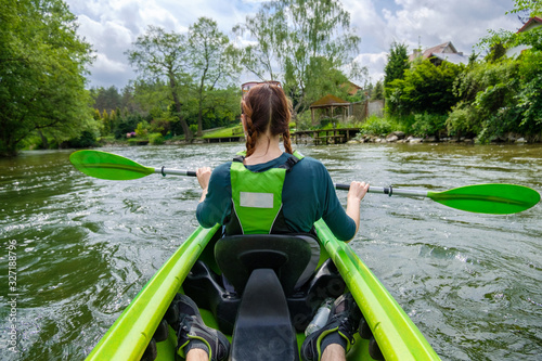 A woman kayaking down the river Wda in Kaszuby, Poland