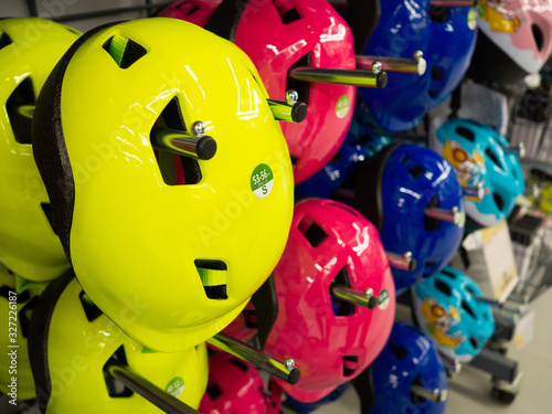 Row of new Bicycle kids helmets close up in the sports store