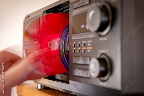 A red colored CD is placed into its player