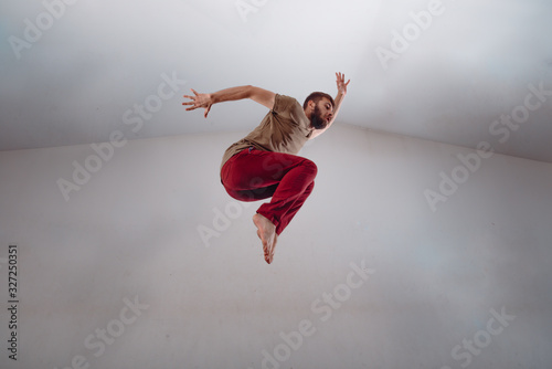 Modern dance performer practicing modern dance on white wall