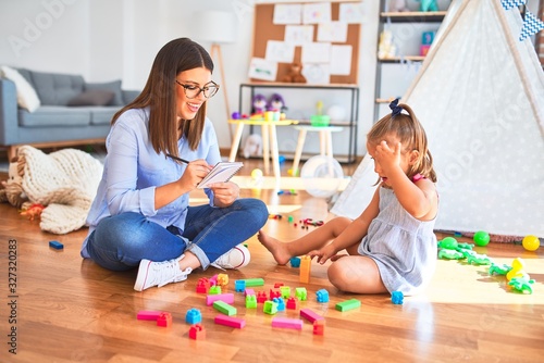 Young therapist woman speaking and treating child, counselor and behaviour correction at pedagogue payroom taking notes on clipboard