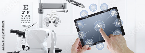 hands touch screen of digital tablet with ophthalmologist and optometrist icons symbols, ophthalmology and optometry equipment on background