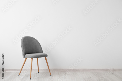 Chair near white wall in room