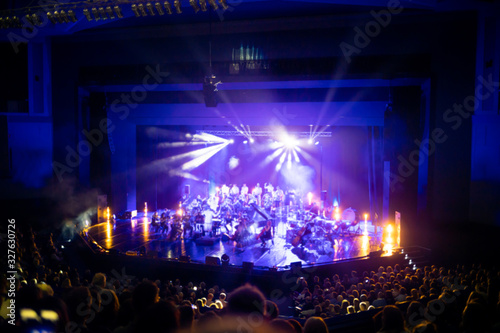 Lights on stage during concert in hall filled with spectators