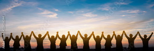 Silhouette of group happy business team making high hands over head in beautiful sunset sky evening time for business success and teamwork concept in company