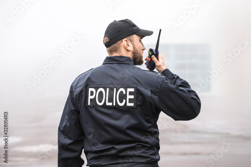 Male police officer patrolling city street