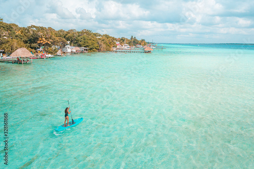 Girl doing paddleboard in Bacalar Lagoon, near Cancun in Riviera Maya, Mexico